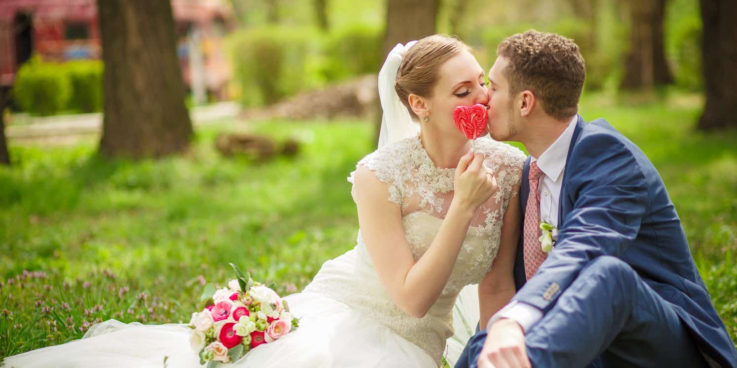 Bride and groom kissing in garden
