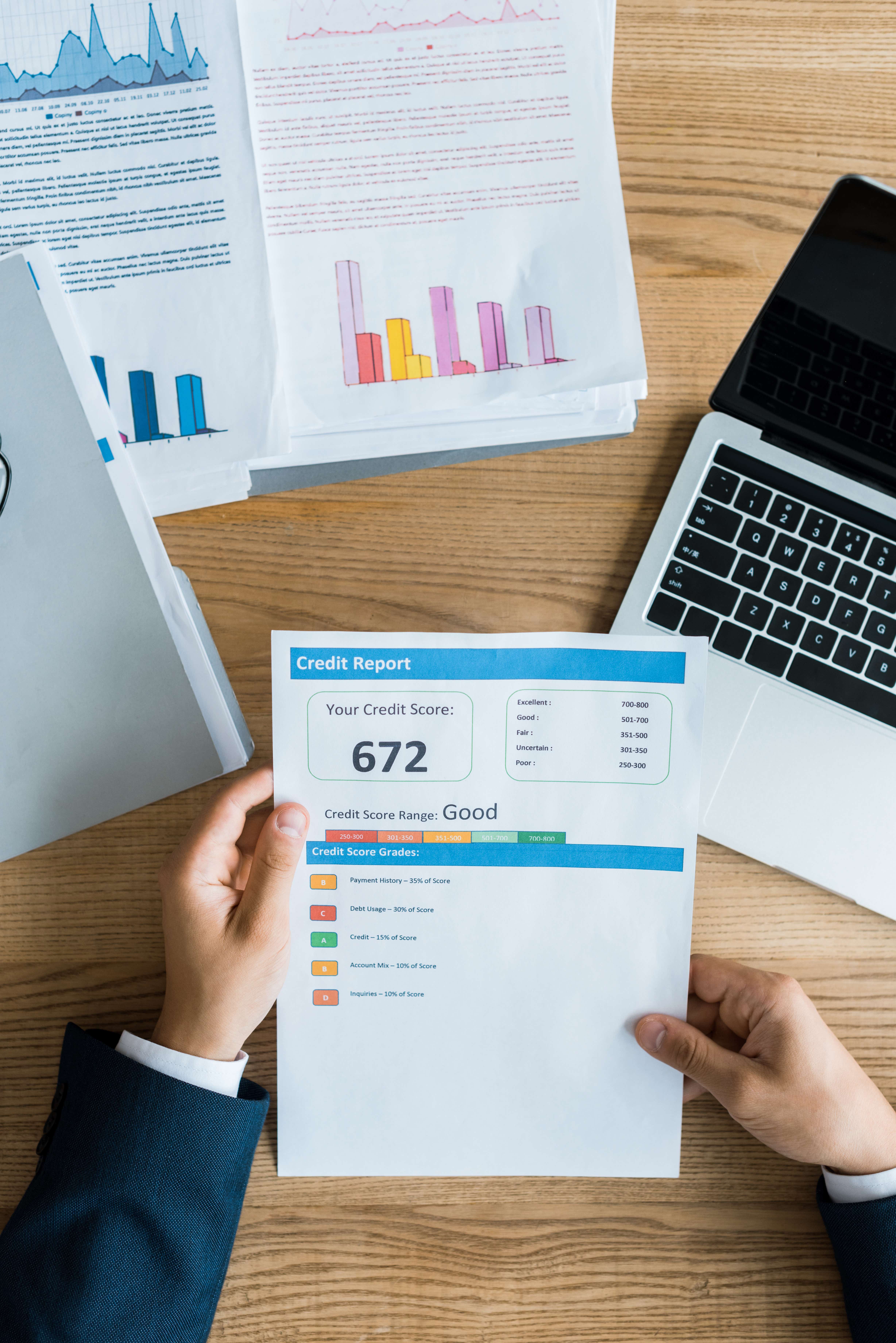credit report, pages of financial graphs and a computer