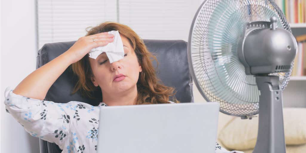heatwave woman fanning herself sweating