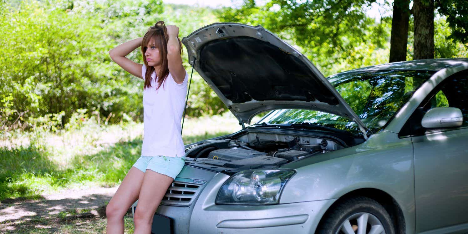 Girl standing by broken down car
