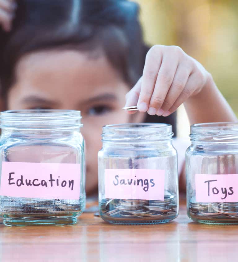 Young girl separating money into jars