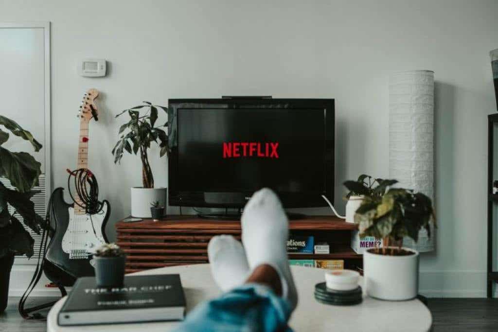 Man sitting with feet on the table and watching Netflix on the TV