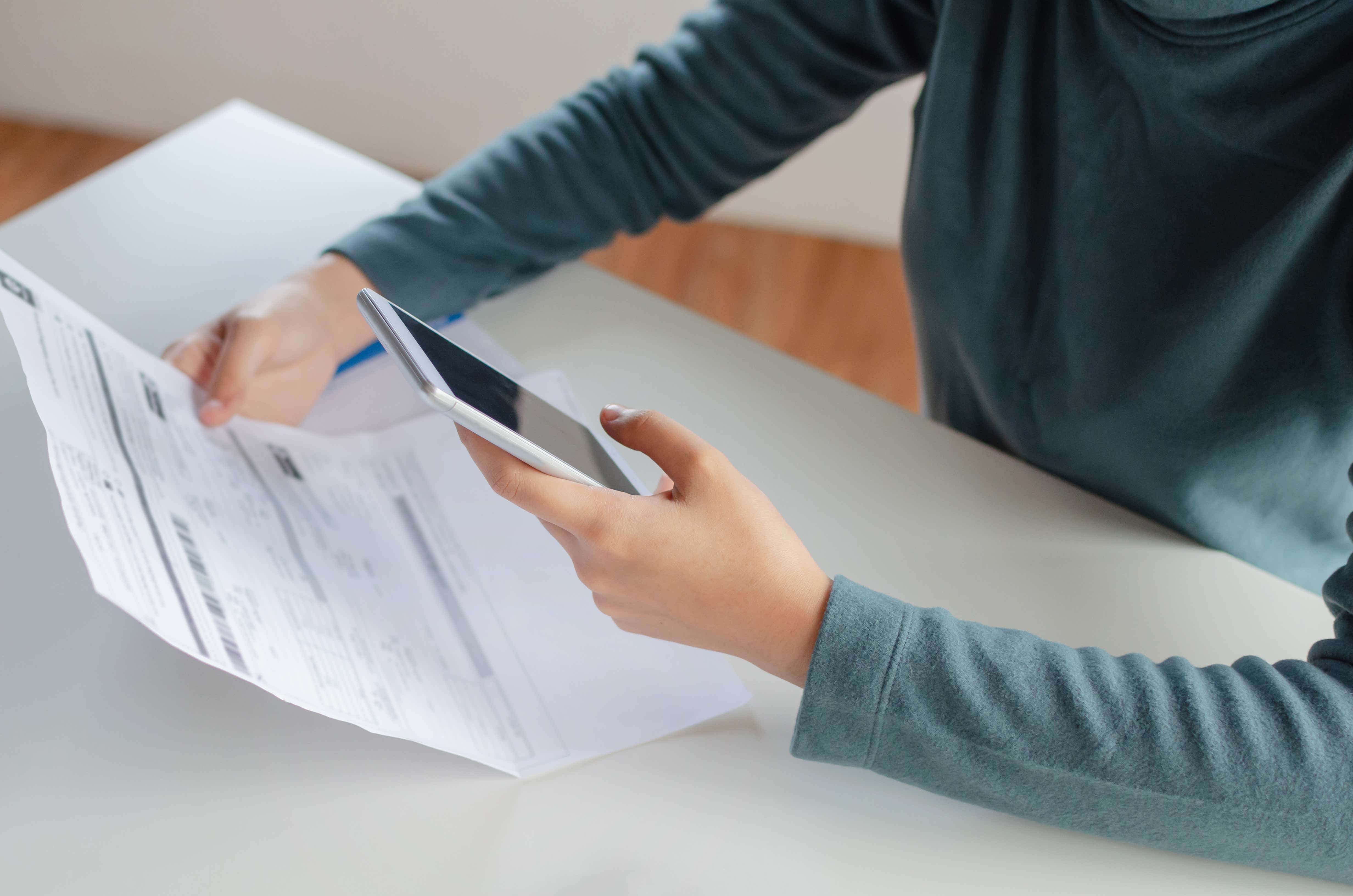 Lady holding a mobile phone looking at her credit report