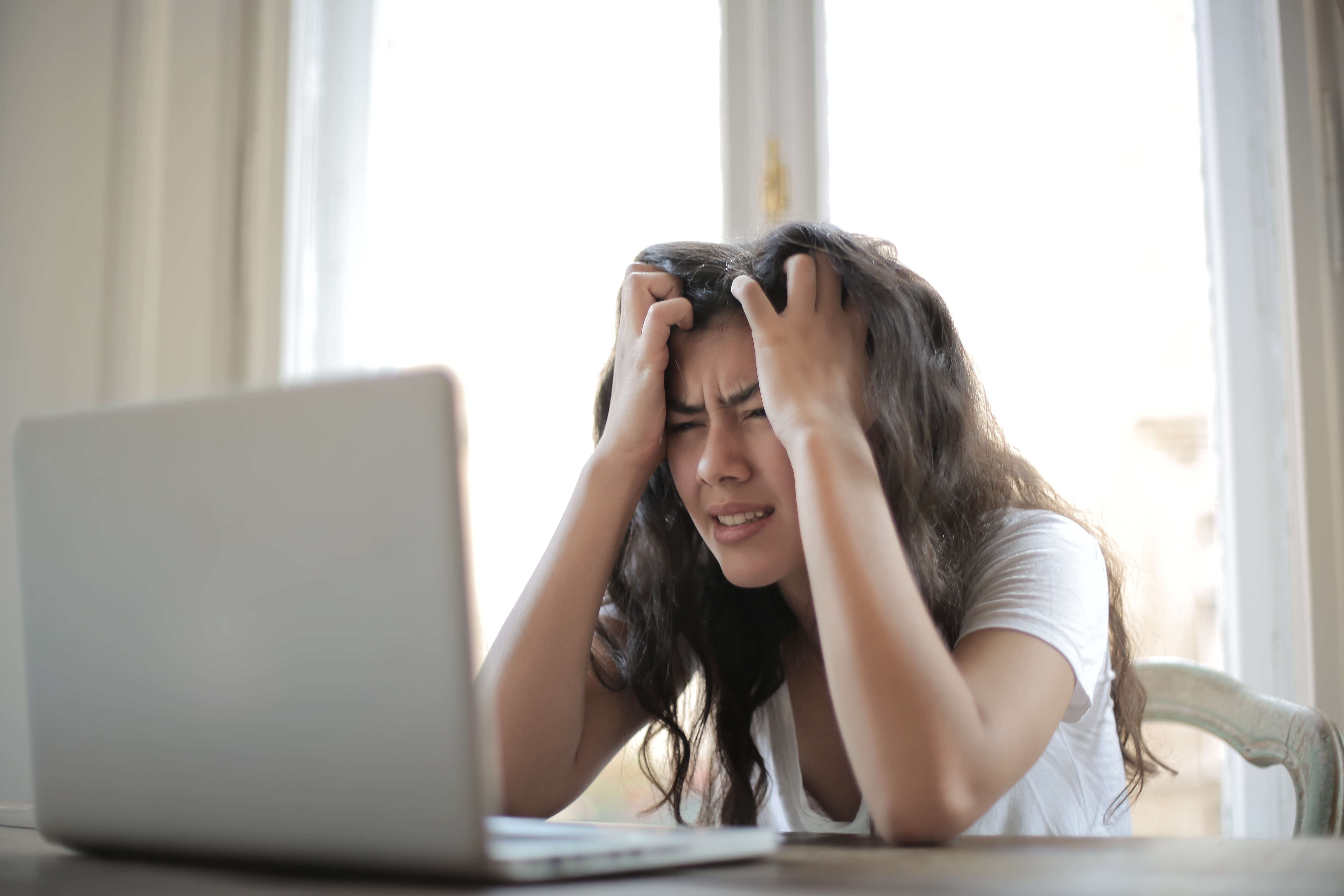 Woman stressed looking down at her laptop