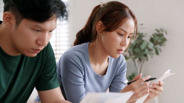 A couple try to calculate their finances.