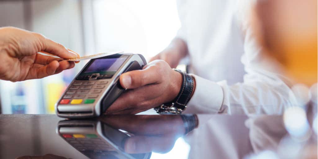 Photographic of a man making a transaction through contactless payment 