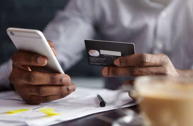 What is PPI image 2 man using phone and credit card