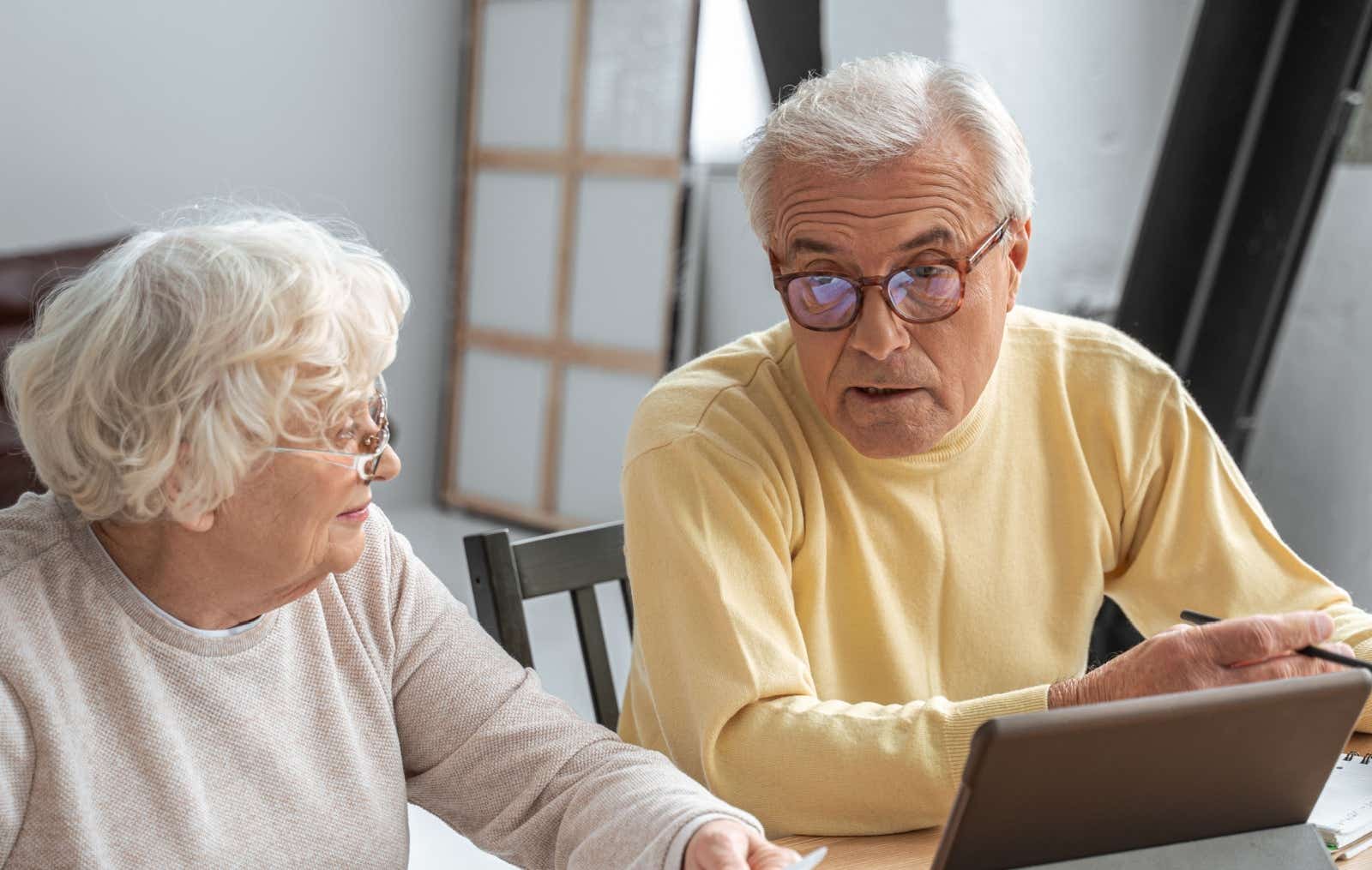 A couple discuss their options while working on a shared laptop.