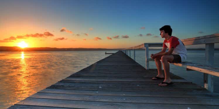boy-watching-the-sunset-from-pier