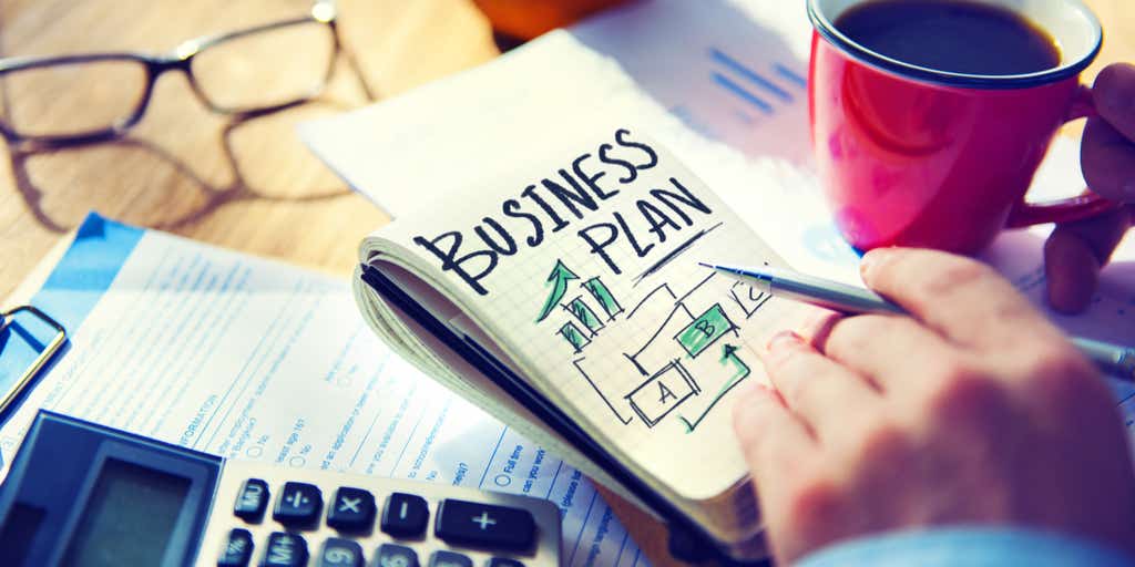 Image of business plan and someone writing one with a cup of coffee