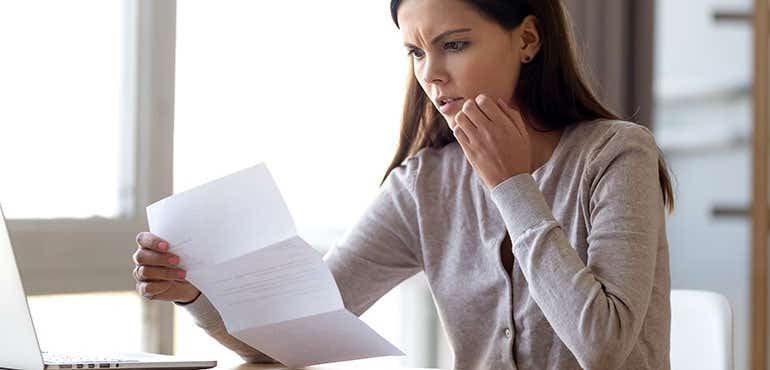 person looking confused at her bills while baying online
