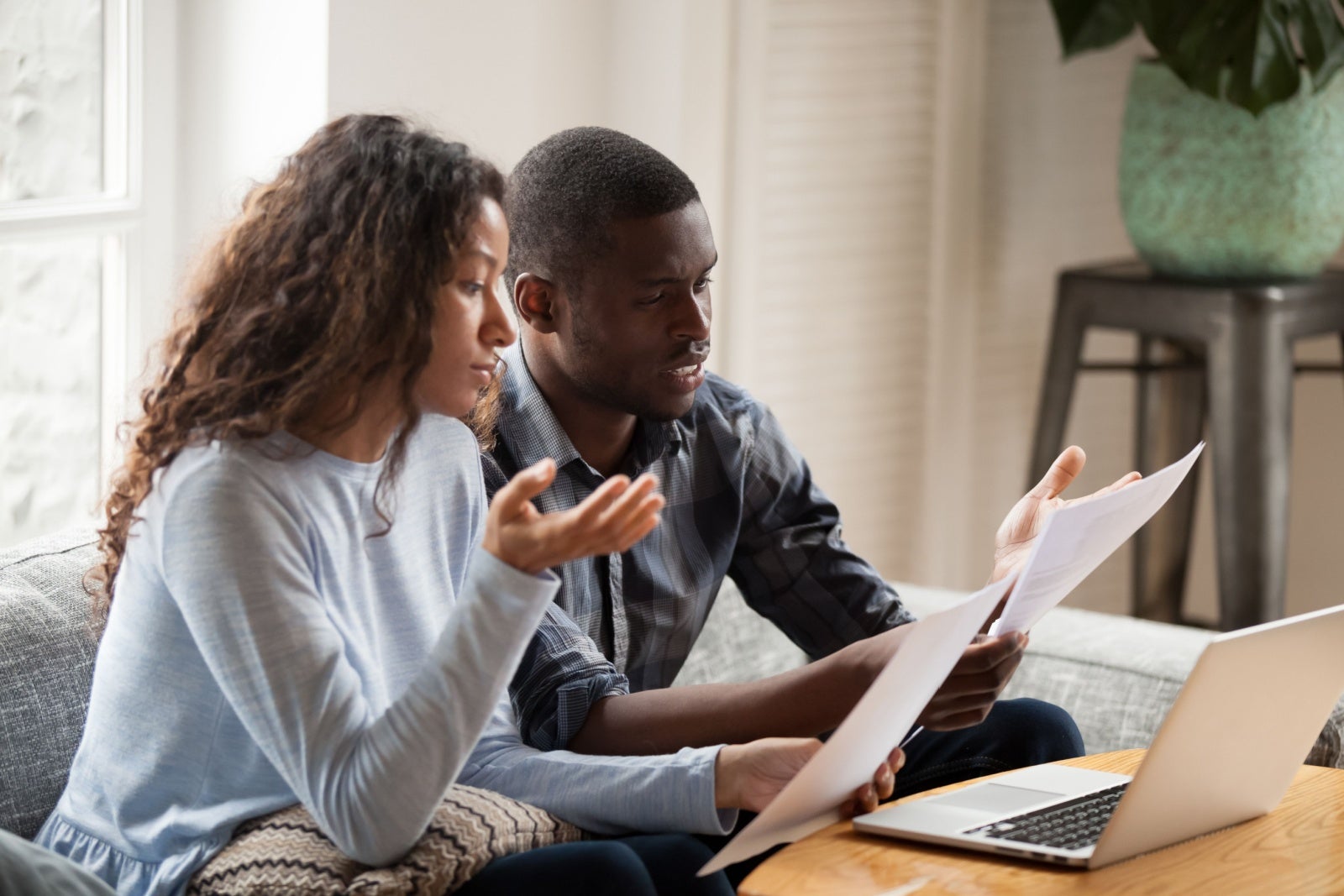 An exasperated couple look at their paperwork.