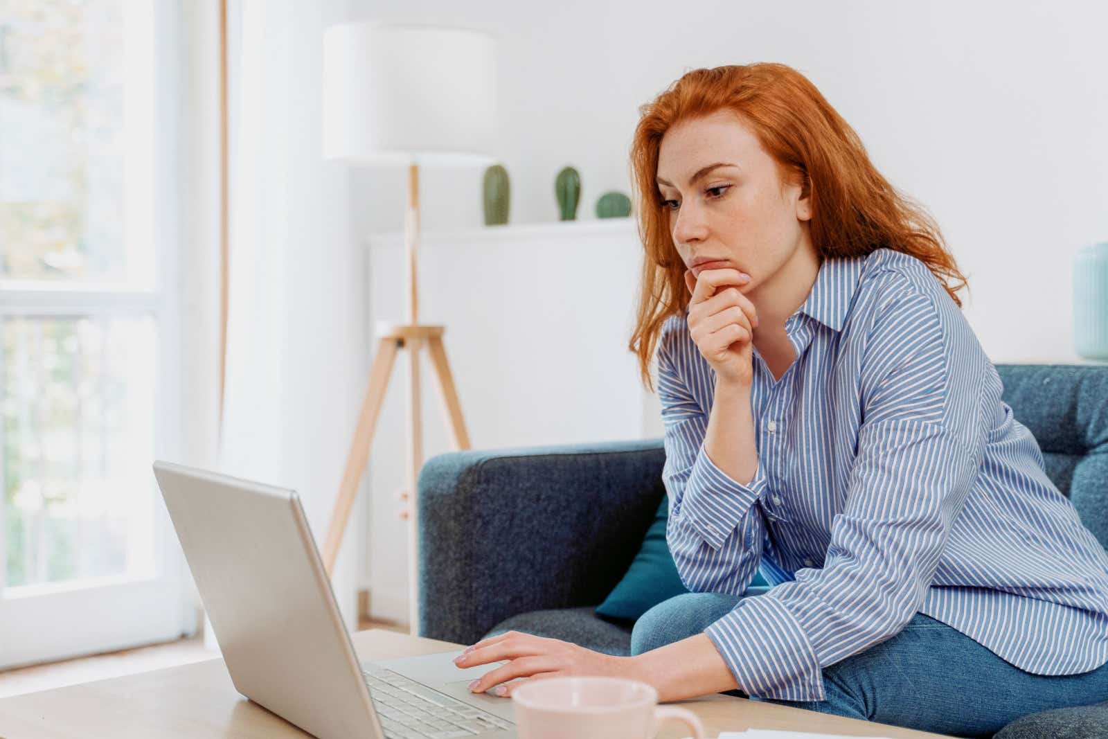 Woman at home looking at her laptop screen