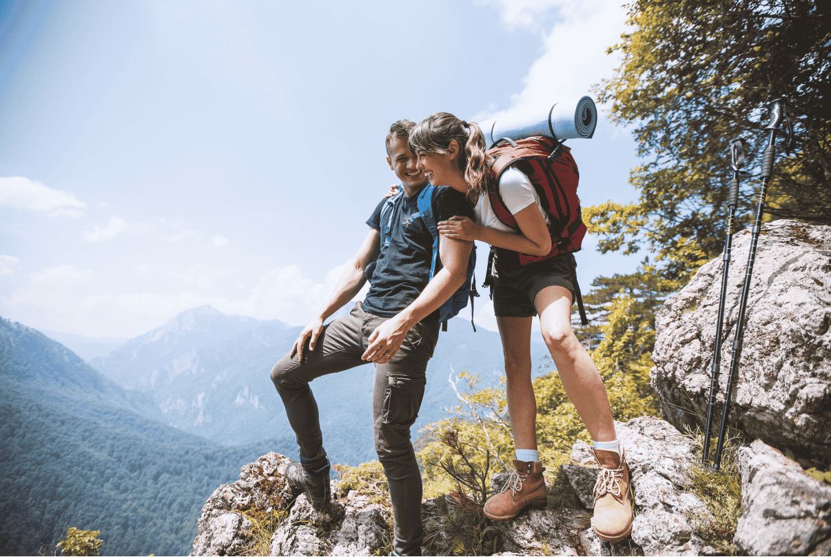 Two people on a hike laughing and looking at the view