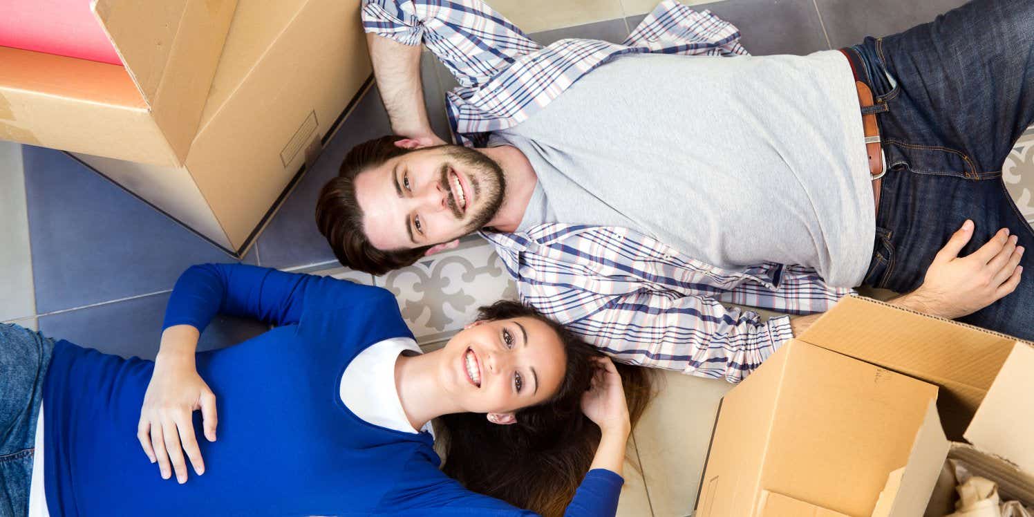 Young couple lying among packing boxes