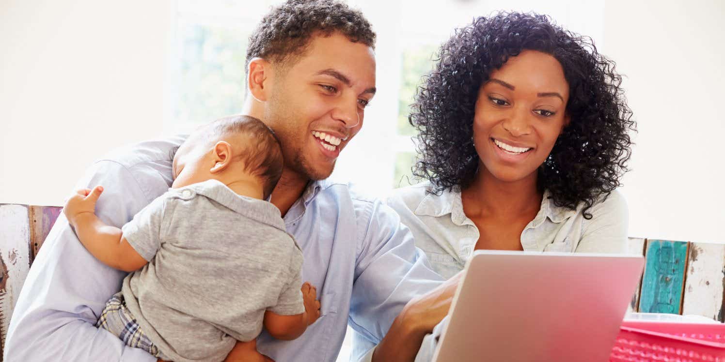 Couple with baby using laptop