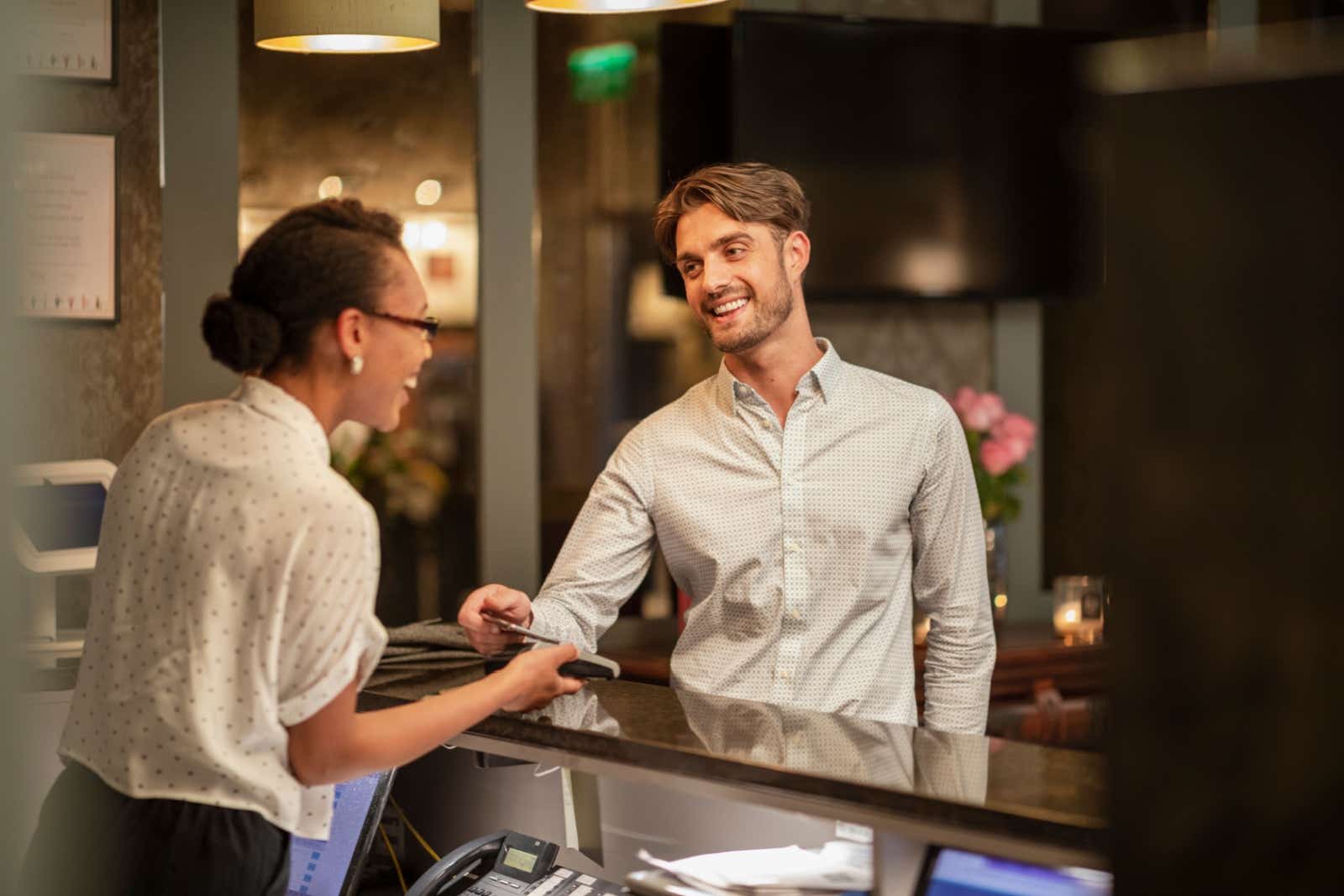 Businessman paying his bill at a hotel reception desk