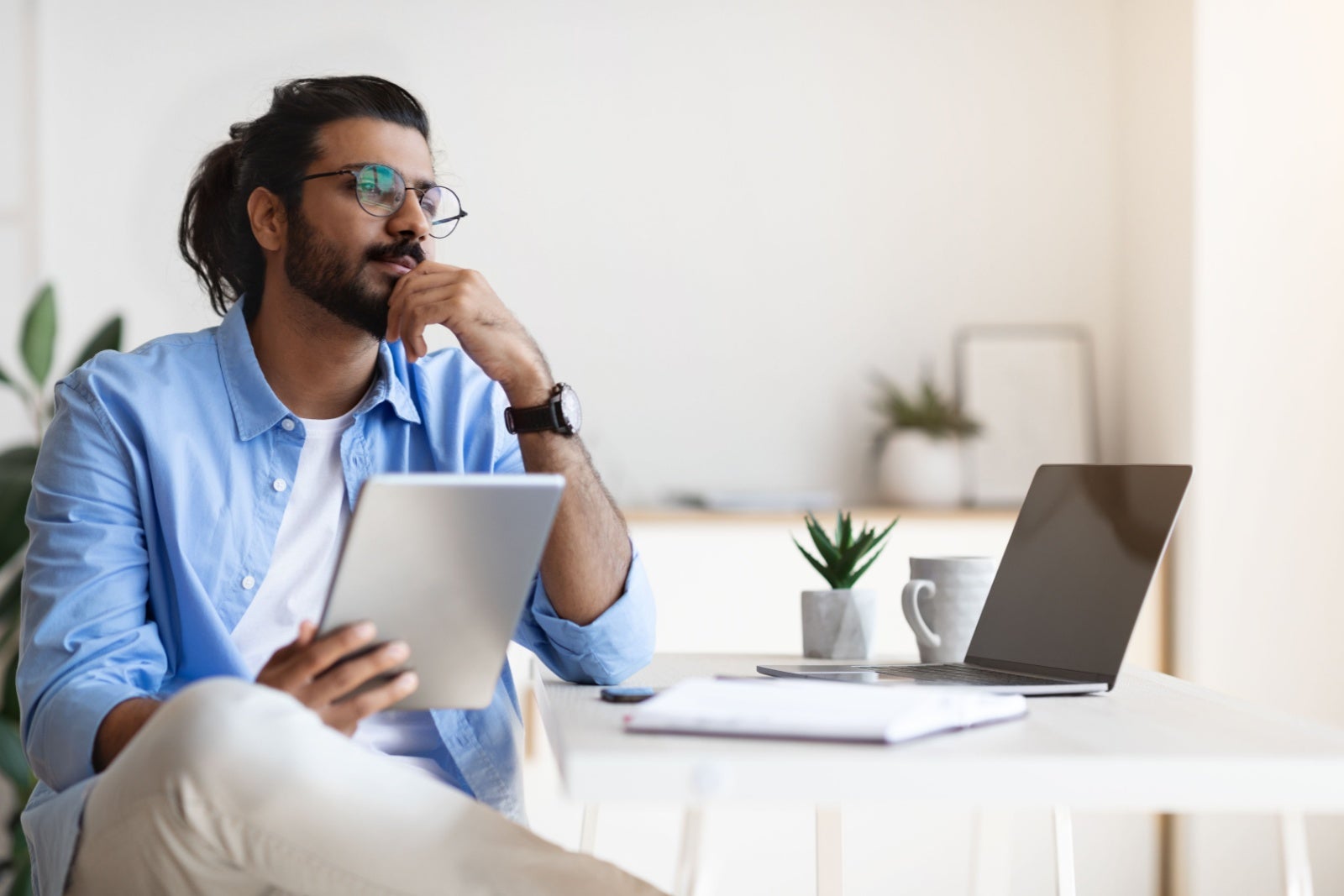 Laid-back businessman considering his options in minimalist office