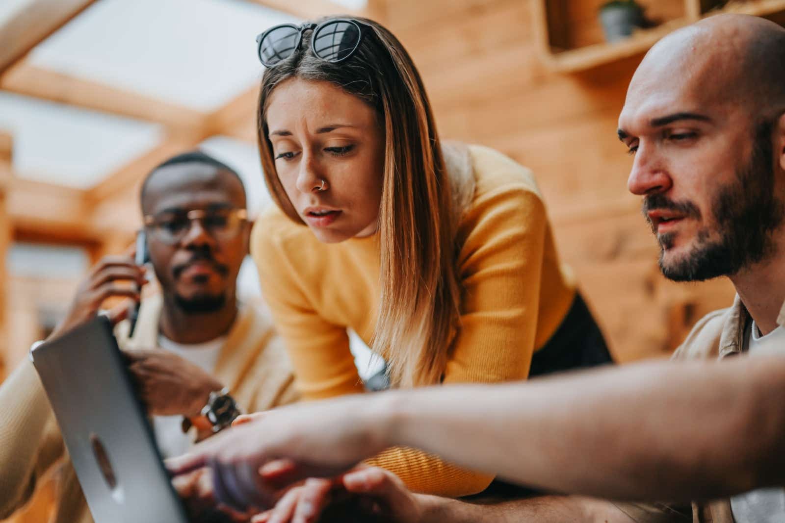 Business people gathered around a laptop.