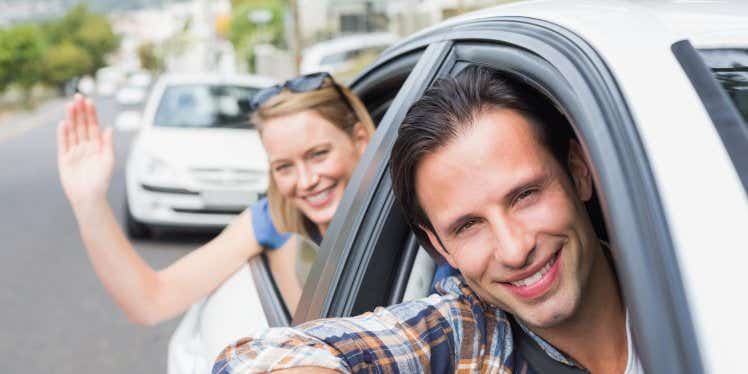 man-and-woman-smiling-while-driving-car.CDN5e66117f