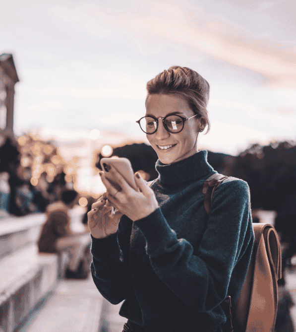 Woman smiling and looking at mobile phone