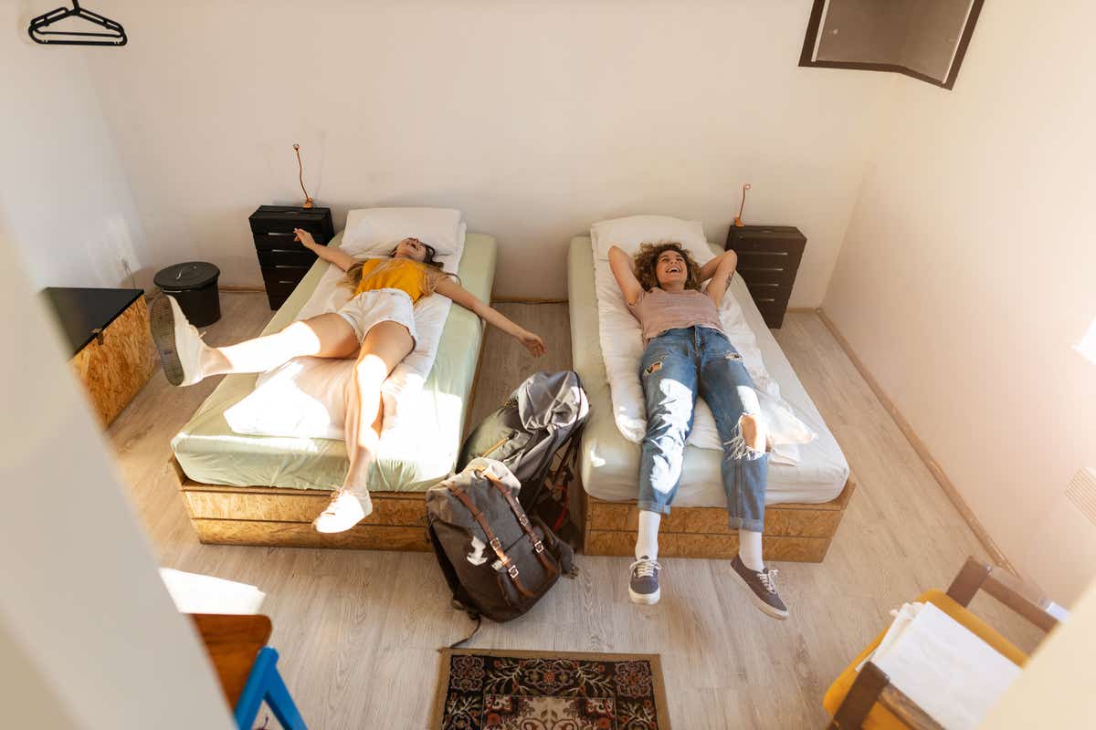 Two friends relax in a hotel room while on holiday