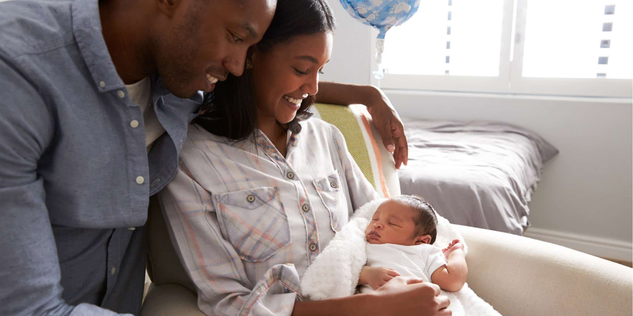 Happy and young black family with newborn baby.