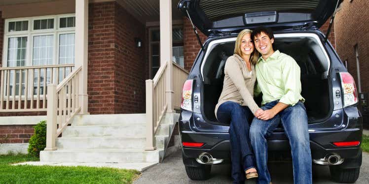 couple-sat-in-car-on-driveway