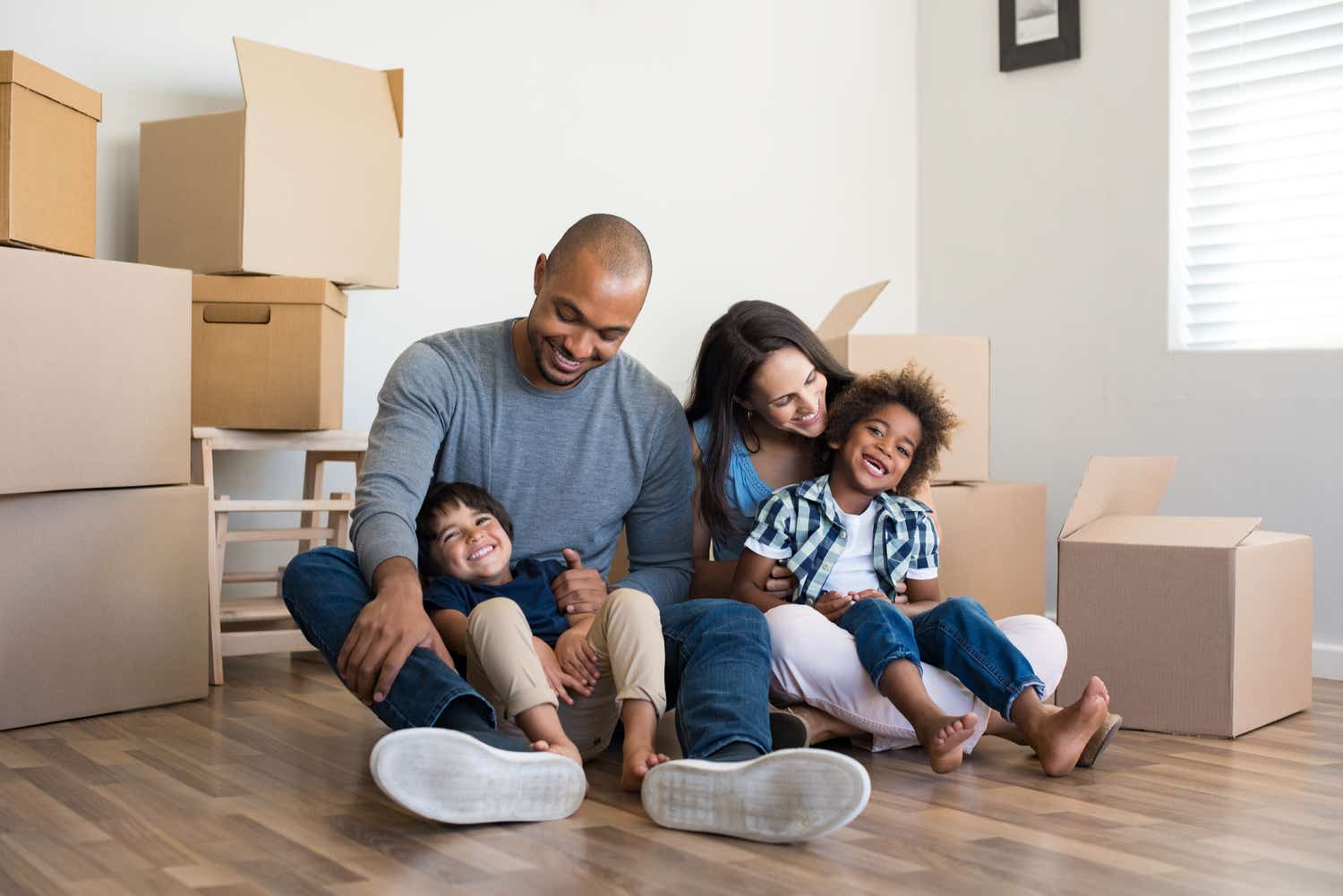 black family surrounded by moving boxes enjoying time together in new home