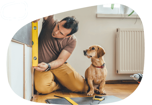 A man measuring something in his home with his dog next to him