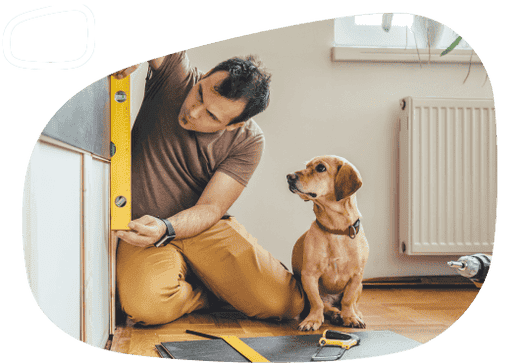 A man measuring something in his home with his dog next to him