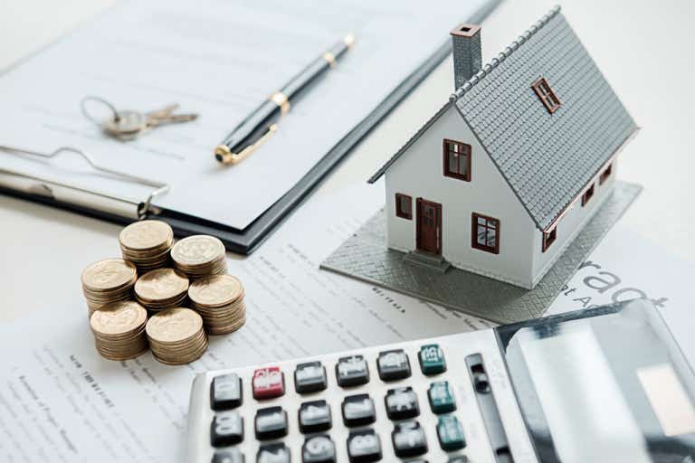 Image of model house surrounded by finances and calculator