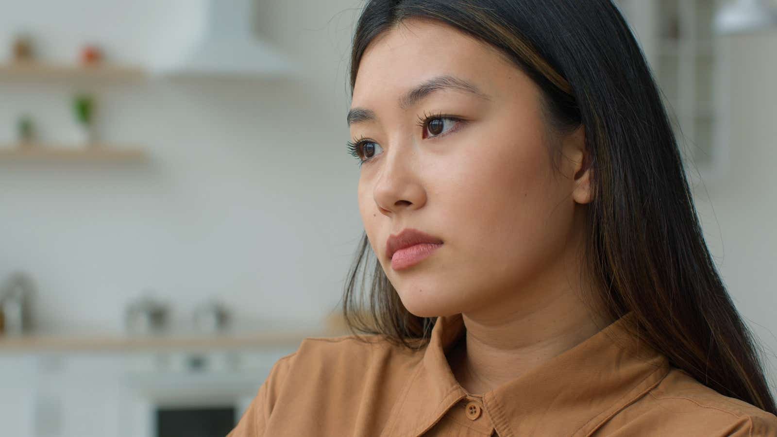 Woman at home staring into space as she thinks