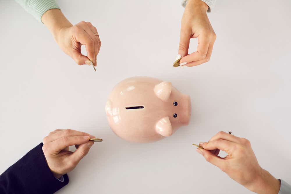 Hands putting money in piggy bank